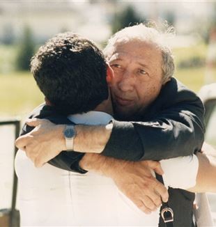 Uścisk między księdzem Giussanim i Jesúsem Carrascosą podczas międzynarodowych wakacji CL w Corvarze w 1985 r.  (©Federico Brunetti)